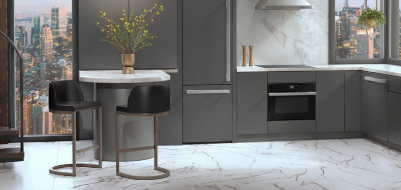 A modern grey kitchen with marble floor and backsplash.